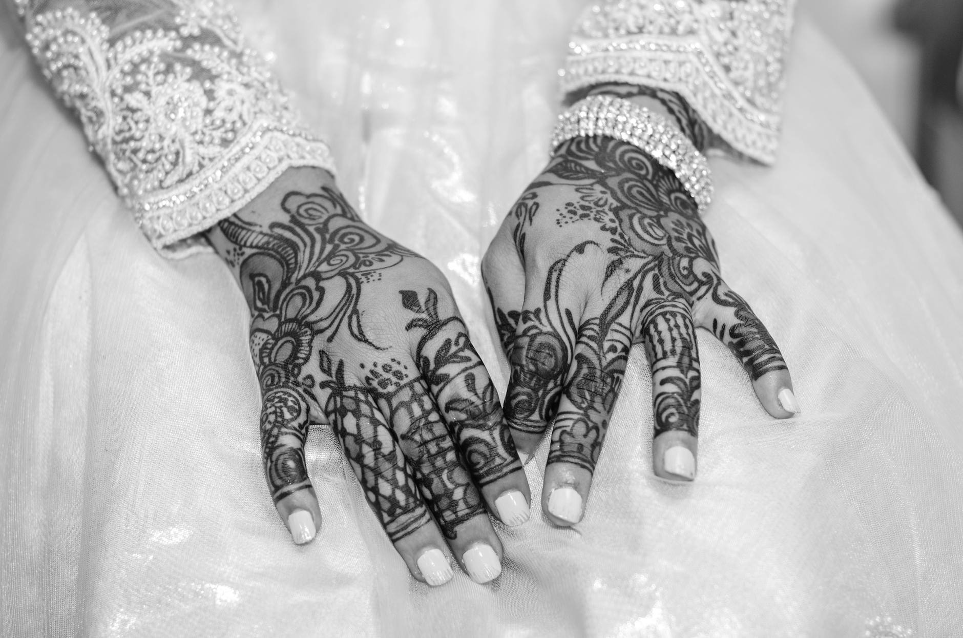 Dłonie panny młodej z misternymi tatuażami mehendi w stylu glamour