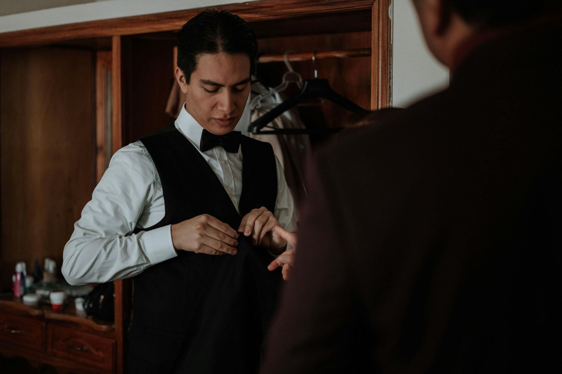 Pan młody poprawia kamizelkę przed ślubem w domu