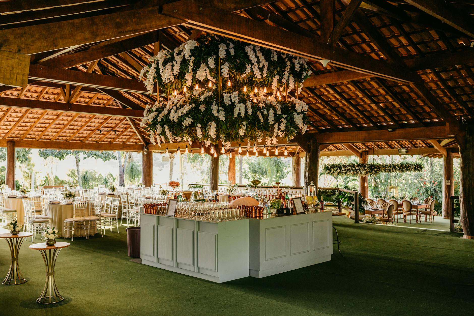 Rustyczna sala weselna z kwiatowymi żyrandolami i eleganckimi stołami