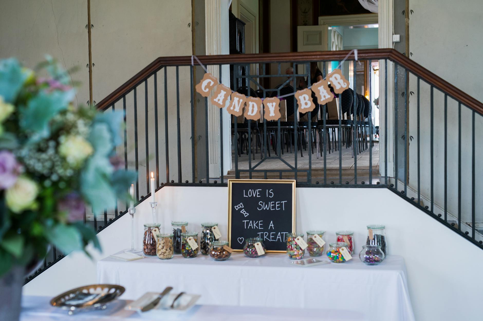 Elegancki candy bar w sali weselnej z kolorowymi słodyczami w słoikach Elegancki candy bar w sali weselnej z kolorowymi słodyczami w słoikach
