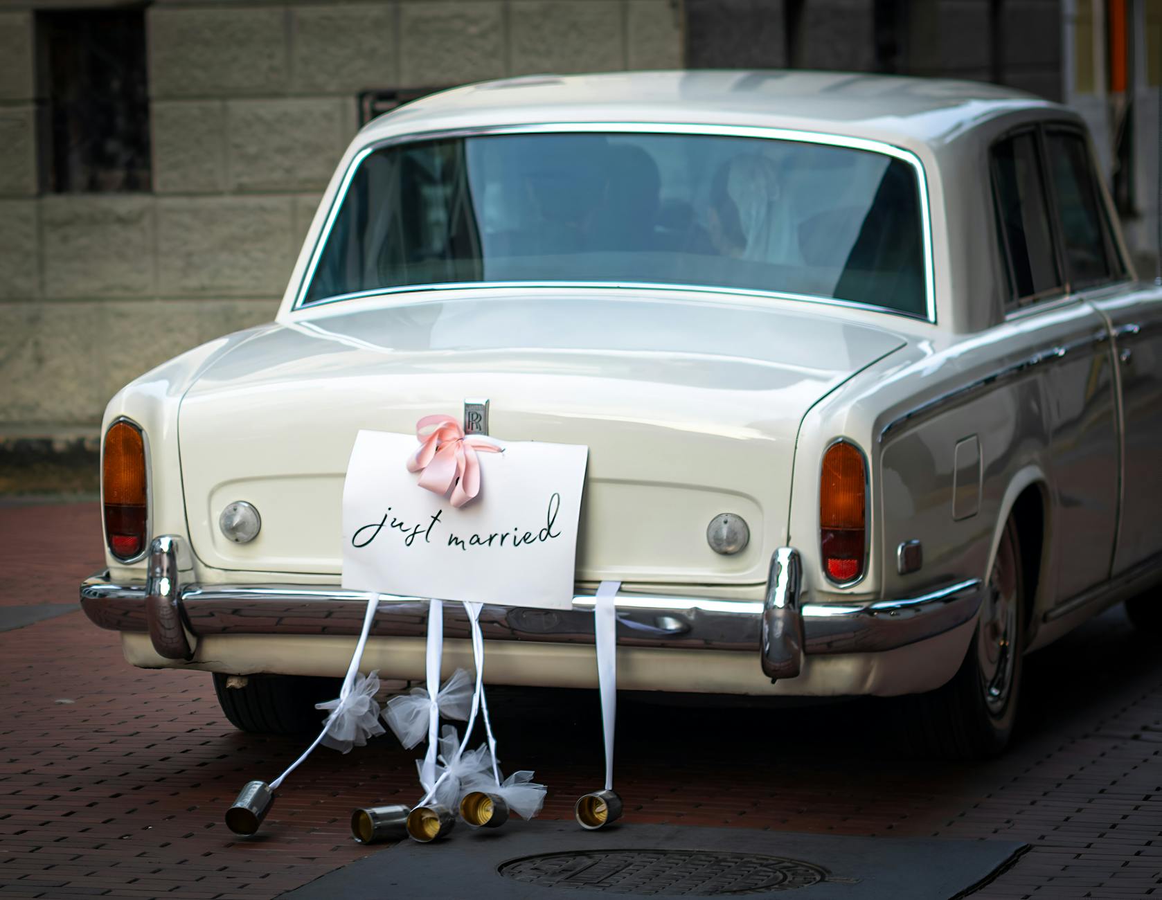 Klasyczny biały Rolls Royce z napisem Just Married jako auto do ślubu
