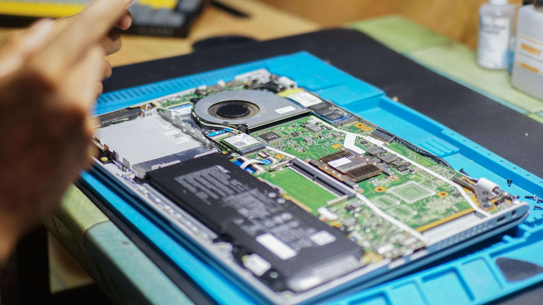 Serwisant naprawia otwartego laptopa Toshiba Satellite na biurku