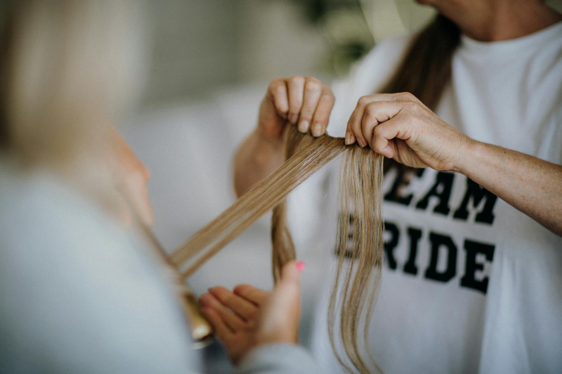 Stylista układa długie włosy panny młodej w hollywoodzkie fale
