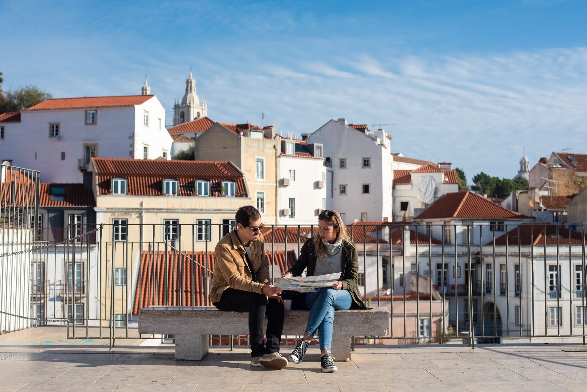 Para na ławce planuje city break nad dachami Lizbony Para na ławce planuje city break nad dachami Lizbony